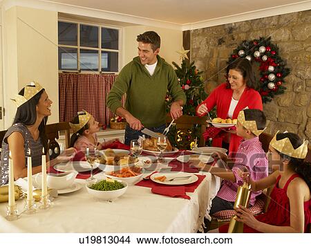 Picture - Hispanic family serving Christmas dinner. Fotosearch