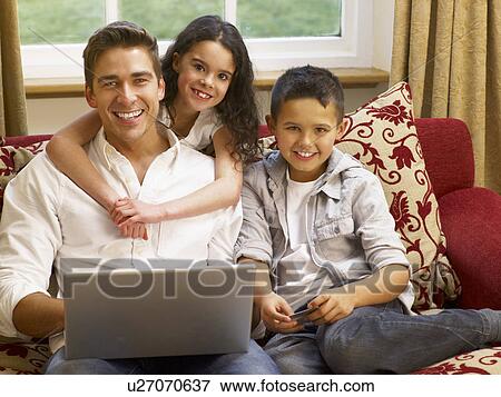 Stock Photo - Hispanic father and children shopping online. Fotosearch