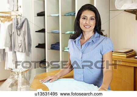 Stock Photography - Hispanic woman working in fashion store. Fotosearch