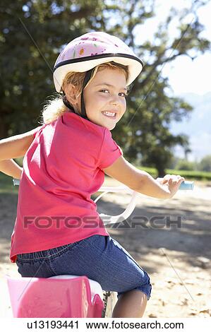 Stock Image - Little girl on country bike ride. Fotosearch