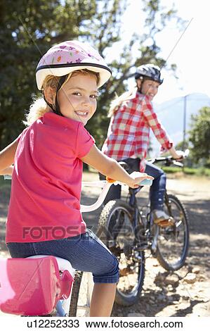 Little girl on country bike ride with mom View Large Photo Image Stock Image - Little girl on country bike ride with mom. Fotosearch