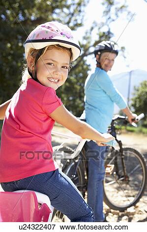 Stock Photo - Little girl on country bike ride with grandma. Fotosearch