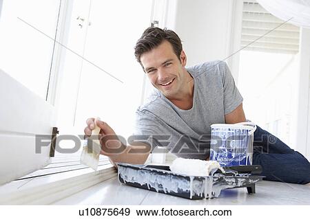 Stock Photo - Man decorating house. Fotosearch