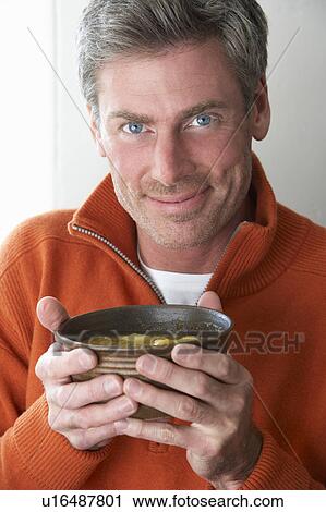 Stock Image - Man holding bowl of soup. Fotosearch