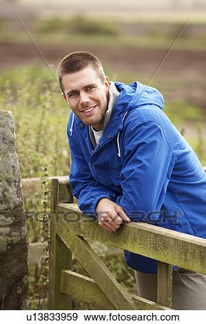 Man leaning on country gate View Large Photo Image Stock Photo - Man leaning on country gate. Fotosearch