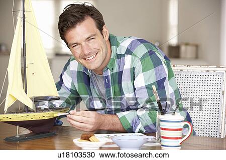 Stock Image - Man making model ship. Fotosearch