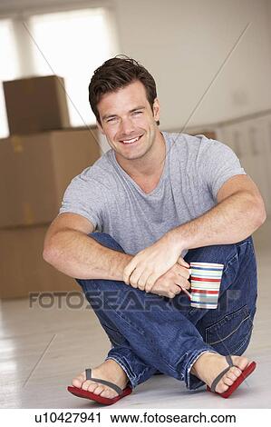 Stock Image - Man moving into new home. Fotosearch