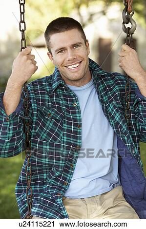 Man on country garden swing View Large Photo Image Stock Image - Man on country garden swing. Fotosearch