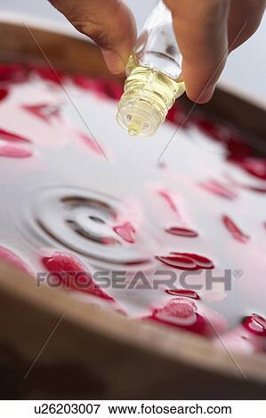 Stock Photo - Man pouring essential oil into water. Fotosearch