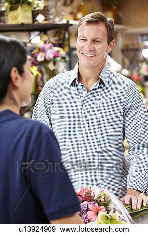 Man serving customer in florist View Large Photo Image Stock Photo - Man serving customer in florist. Fotosearch