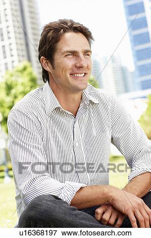 Stock Photo - Man sitting in city park. Fotosearch