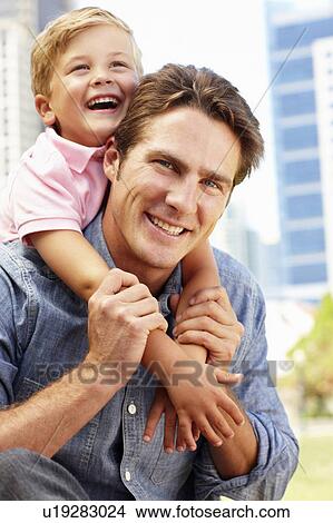 Picture - Man sitting in city park with young son. Fotosearch
