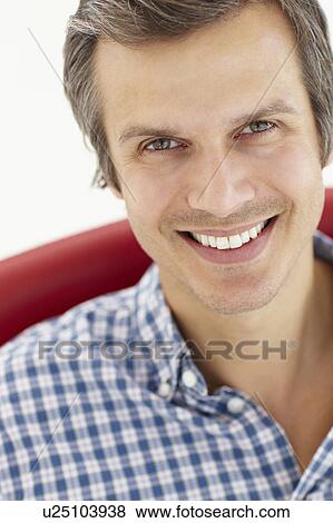 Stock Photo - Man sitting in red chair. Fotosearch