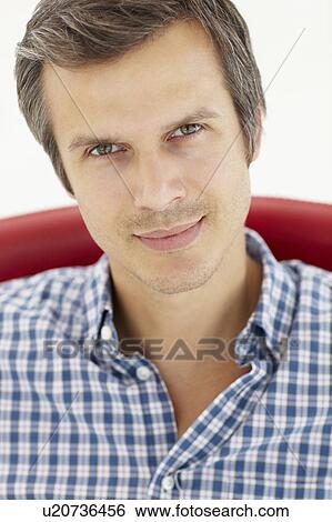 Stock Photograph - Man sitting in red chair. Fotosearch