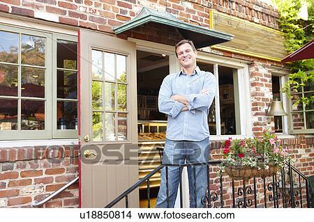 Man standing outside bakery/café View Large Photo Image Picture - Man standing outside bakery/café. Fotosearch