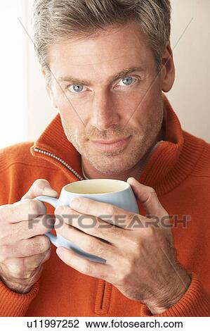 Man with hot drink View Large Photo Image Stock Image - Man with hot drink. Fotosearch