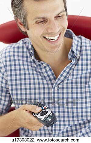 Stock Image - Man with remote control. Fotosearch