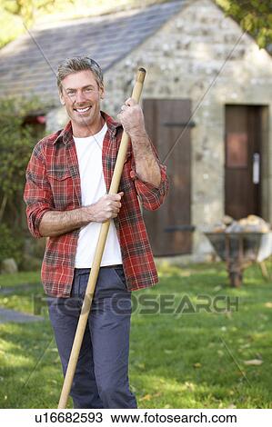Stock Image - Man working in country garden. Fotosearch