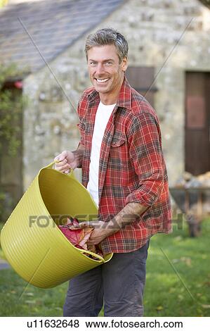 Man working in country garden View Large Photo Image Stock Photo - Man working in country garden. Fotosearch