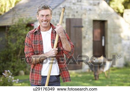 Man working in country garden View Large Photo Image Stock Photo - Man working in country garden. Fotosearch