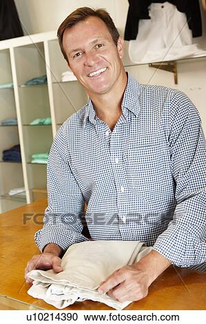 Stock Image - Man working in fashion store. Fotosearch