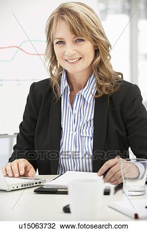 Mid age businesswoman at work View Large Photo Image Stock Image - Mid age businesswoman at work. Fotosearch