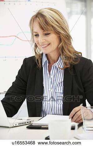 Mid age businesswoman at work View Large Photo Image Stock Photo - Mid age businesswoman at work. Fotosearch
