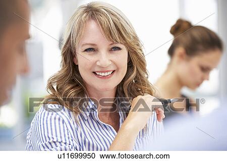 Mid age businesswoman in meeting View Large Photo Image Stock Image - Mid age businesswoman in meeting. Fotosearch