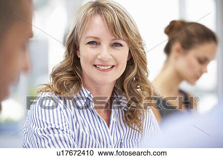 Mid age businesswoman in meeting View Large Photo Image Stock Image - Mid age businesswoman in meeting. Fotosearch
