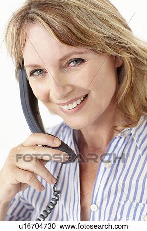Stock Image - Mid age businesswoman on phone. Fotosearch
