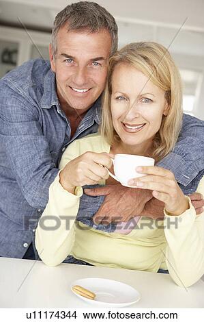 Mid age couple with coffee at home View Large Photo Image Picture - Mid age couple with coffee at home. Fotosearch