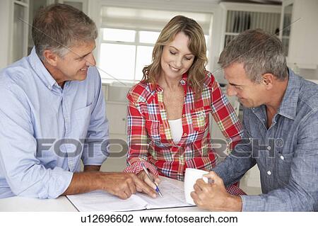 Mid age couple with financial advisor at home View Large Photo Image Stock Image - Mid age couple with financial advisor at home. Fotosearch
