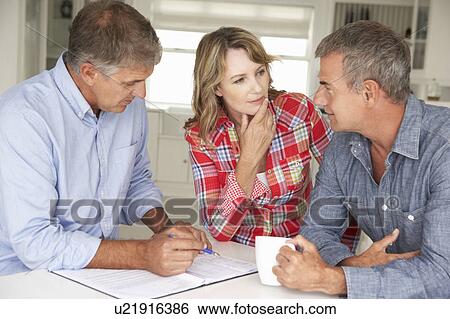 Mid age couple with financial advisor at home View Large Photo Image Stock Photograph - Mid age couple with financial advisor at home. Fotosearch