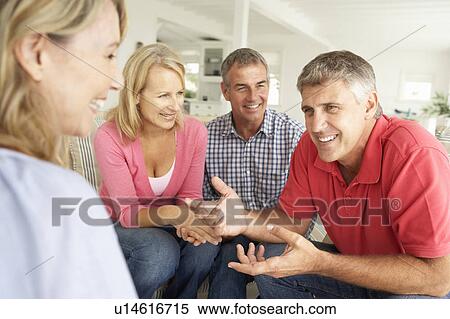 Stock Photography - Mid age couples chatting at home. Fotosearch