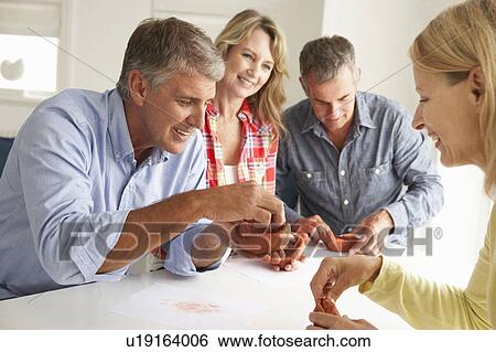 Stock Photograph - Mid age couples clay modelling. Fotosearch