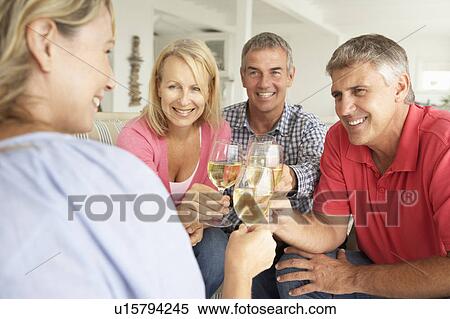 Stock Photography - Mid age couples drinking together at home. Fotosearch
