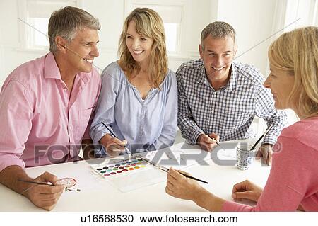 Stock Image - Mid age couples painting with watercolors. Fotosearch