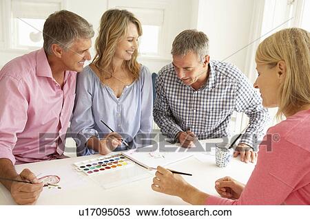 Stock Image - Mid age couples painting with watercolors. Fotosearch