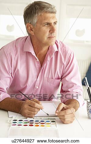 Stock Photo - Mid age man painting with watercolors. Fotosearch