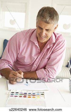 Stock Photograph - Mid age man painting with watercolors. Fotosearch