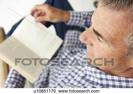 Mid age man reading a book View Large Photo Image Stock Image - Mid age man reading a book. Fotosearch