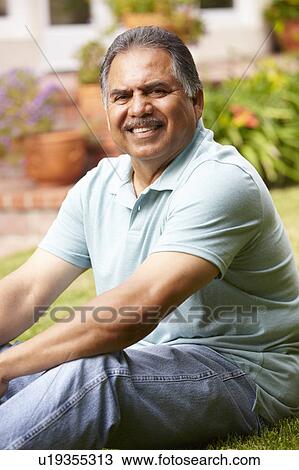 Mid age man relaxing in garden View Large Photo Image Stock Image - Mid age man relaxing in garden. Fotosearch