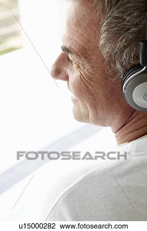 Mid age man wearing headphones View Large Photo Image Stock Image - Mid age man wearing headphones. Fotosearch