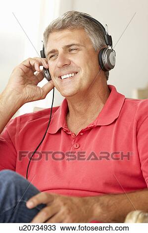 Stock Image - Mid age man wearing headphones. Fotosearch