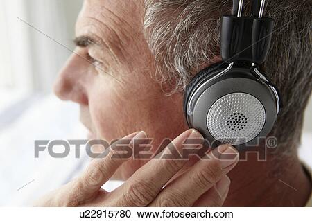 Mid age man wearing headphones View Large Photo Image Stock Image - Mid age man wearing headphones. Fotosearch