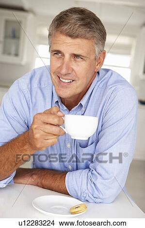 Mid age man with coffee at home View Large Photo Image Picture - Mid age man with coffee at home. Fotosearch