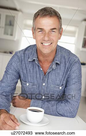 Mid age man with coffee at home View Large Photo Image Stock Image - Mid age man with coffee at home. Fotosearch