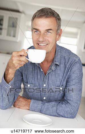 Stock Photo - Mid age man with coffee at home. Fotosearch