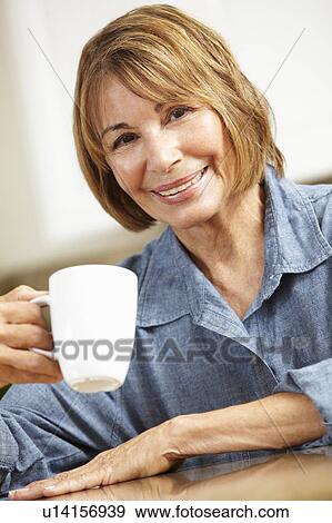 Stock Photo - Mid age woman drinking coffee. Fotosearch