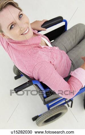 Stock Image - Mid age woman in wheelchair. Fotosearch